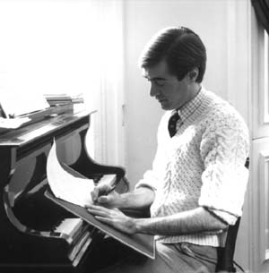 David seated at the piano while composing.