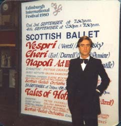 David Earl stands in front of a poster advertising the Scottish Ballet production of his ballet Cheri
